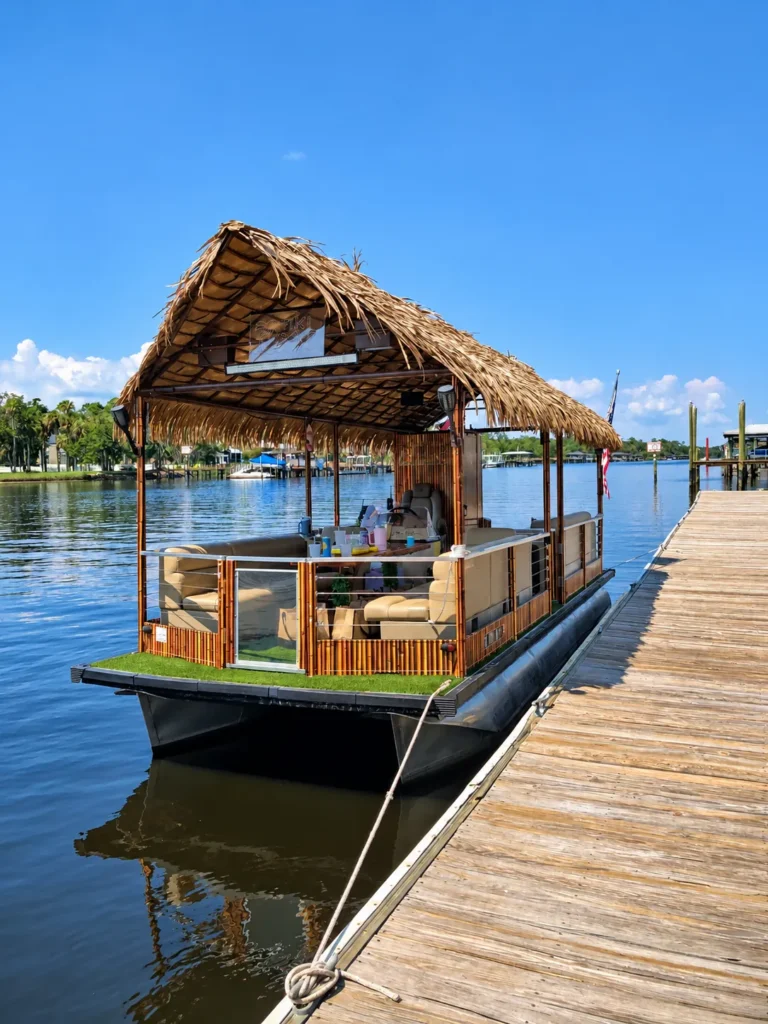 Tiki party boat in Jacksonville with a thatched roof, docked on the river