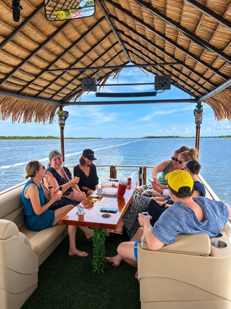 Friends sharing snacks at the table on a tiki boat party cruise