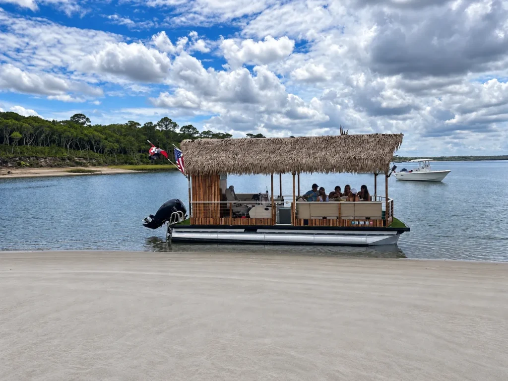 Tiki party boat anchored at a Jacksonville sandbar with guests on board